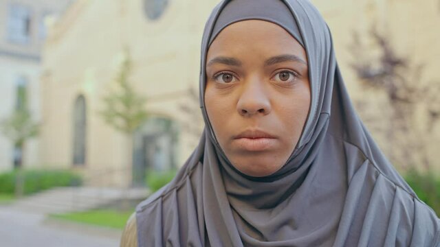 Black muslim female in hijab looking at camera, women's rights, islamic culture