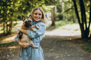 Young woman with her pet french bulldog in park