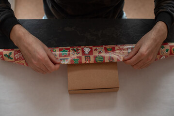 Obraz premium A man is packing a gift