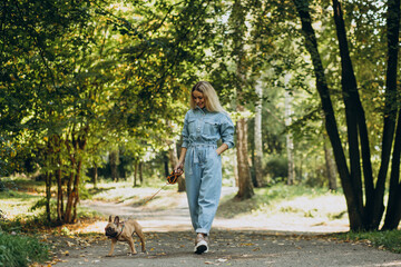 Young woman with her pet french bulldog in park