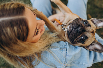 Young woman with her pet french bulldog in park