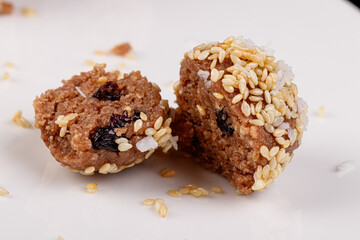 Beautiful candies with sesame seeds on a white plate on a black background