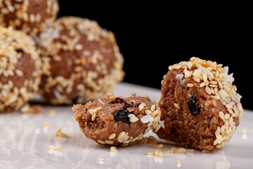 Beautiful candies with sesame seeds on a white plate on a black background