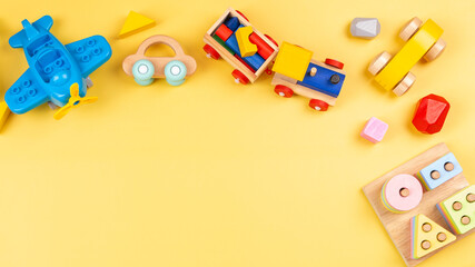 Baby kids toy for children. Educational wooden and plastic toys on yellow background. Top view, flat lay