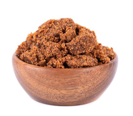 Muscovado sugar in wooden bowl, isolated on white background. Barbados sugar, khandsari or khand.