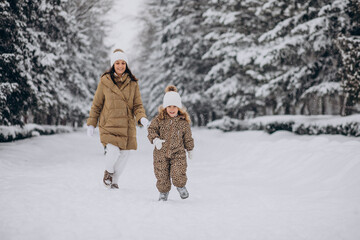 Mother and daughter having fun at park full of snow