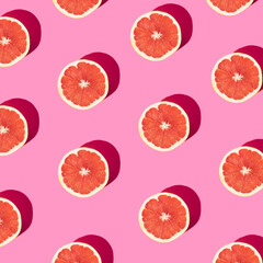Trendy  pattern made with grapefruit slice on pastel  pink background. Minimal fruit concept. Flat lay.