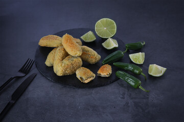Mexican food. Jalapeños battered with lime on dark background
