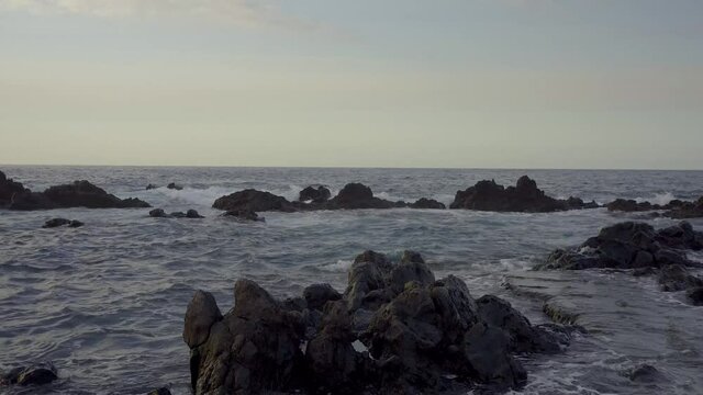 
Rocas negras volc&aacute;nicas ba&ntilde;adas por un fuerte oleaje en aguas del Oc&eacute;ano atl&aacute;ntico en la Isla de Tenerife
