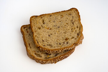 Two slices of wholegrain bread with sesame seeds and dried vegetables. Healthy vegetarian food. Isolated flat lay.