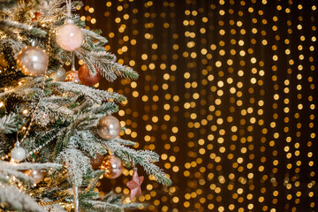 Modern design Christmas tree decorated with balls, toys and garlands - blue, brown, beige, pink, gold colors. Winter holidays composition.