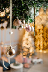 Modern design Christmas tree decorated with balls, toys and garlands - blue, brown, beige, pink, gold colors. Winter holidays composition.
