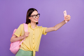 Profile side photo of young cheerful girl shooting selfie cellphone bag study courses isolated over violet color background