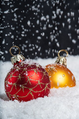 Boules de noel sous la neige qui tombe