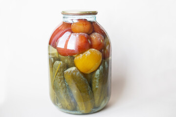 spoiled can of vegetable seaming. Glass jar with homemade pickled tomatos and cucumbers with white...