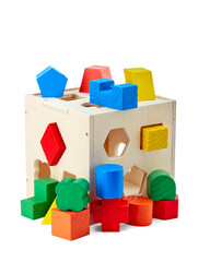 Wooden children's toy that develops a child's fine motor skills, consisting of three-dimensional geometric shapes and holes in a cube for them, isolated on a white background with a shadow.