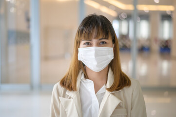 Portrait of young beautiful Business Woman wearing a protective mask in modern office