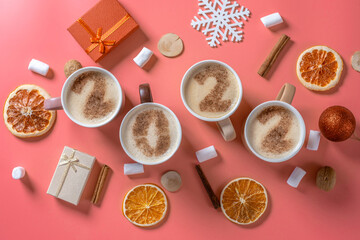 Card with numbers 2022 for New year and Christmas. Cup of coffee with figures on pink background. Top view. Flat lay