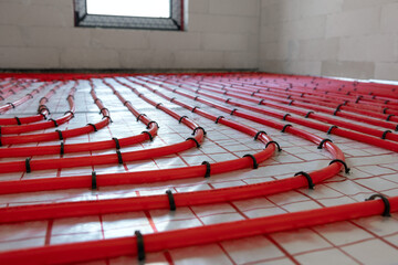 house underfloor heating system installation. red plastic pipes