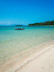 Obraz premium Peaceful white sand beach tropical island with crystal clear turquoise water and local fishing boat. Koh Mak Island, Trat Province, Thailand.
