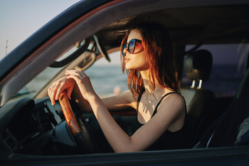 Plakat pretty woman in sunglasses driving a car trip