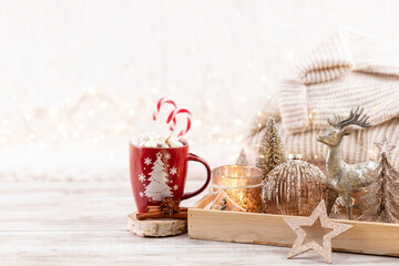 Cup with a hot drink, marshmallow on a table with christmas decorations.