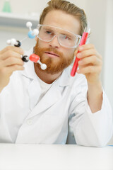 young scientist holding molecular model and test tube