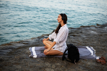 Hot woman relaxing on the sandy beach. Beautiful woman with headphones listening the music