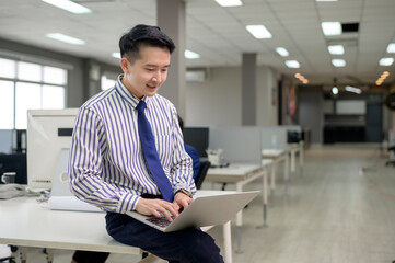 An Asian man is using laptop computer , video calling to business partner in office