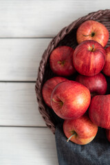 Fresh red apples in a wicker basket. Ripe fruits as a concept of a plentiful harvest. White background.