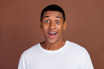 Photo of hooray young brunet guy wear white t-shirt isolated on brown color background