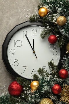 Christmas clock with christmas decoration on grey background. Happy new year concept. Vertical photo.