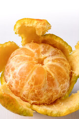 tangerine, peeled fresh mandarin orange, closeup of citrus fruit on white background, macro