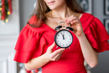 A woman keeps an alarm clock on at five minutes to twelve