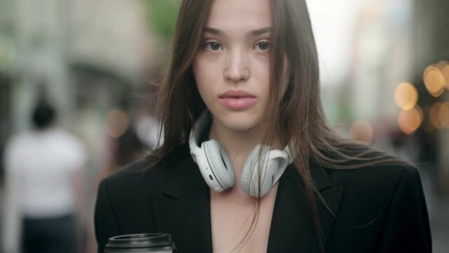 Successful young beautiful woman standing on the old street using smartphone and drinking coffee. Girl work on smart phone. Social networks, online shopping concept. Attractive business gir