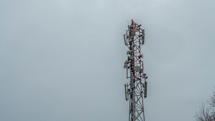 Tower with mobile operator antennas on the dramatic sky background. Tower hosted equipment cellula.