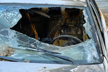 Broken and melted windshield of burnt out car after fire.
