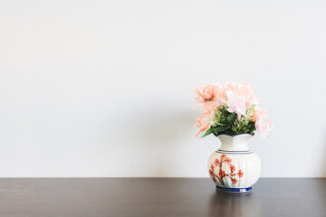 pink flower in jar on wood table with space for text