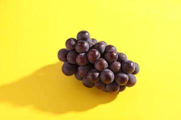 Red grapes isolated in yellow background