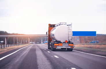 truck with semi-trailer tanker transports dangerous goods on the highway on the background of...