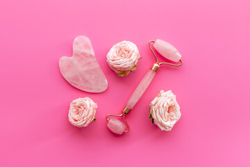 Pink gua sha massage stone with rose flowers for lifting face and wellness