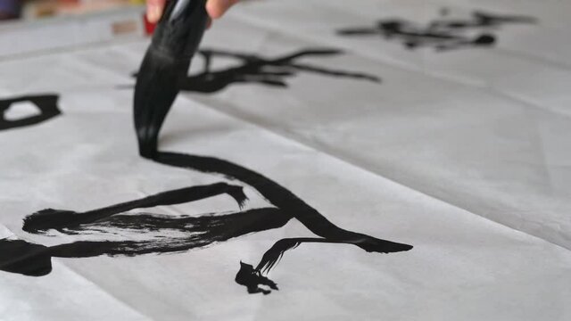 An old calligrapher is writing calligraphy and writing calligraphy