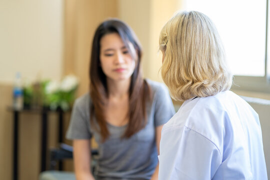 Professional psychiatrist listening to her patient in medical clinic or hospital mental health service