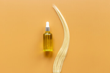 Fototapeta na wymiar Essential oil for hair care with blond hair curl