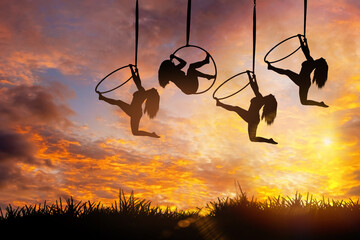 Happy new Year 2022 - Silhouette woman doing aerial hoop or aerial ring on golden sky, Sport for good helth and success in 2022 for new life concept. © somchairakin