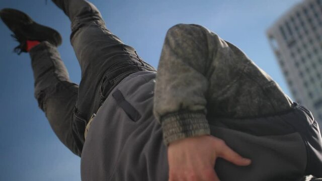 The dancer jumps on one hand and freezes in the air in one position.