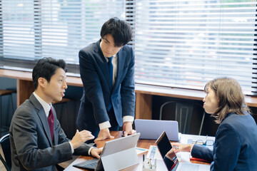 ノートパソコンで会議をする３人の男女のビジネスマン
