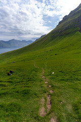 Beautiful aerial view of the Kallur Lighthouse in the Faroe Islands, and its massive cliffs, crags hikes and ocean views