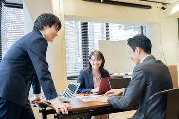 ノートパソコンで会議をする３人の男女のビジネスマン