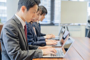 ノートパソコンで仕事をする３人の男女のビジネスマン